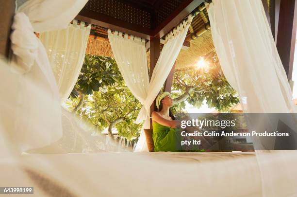 pacific islander woman sitting in gazebo - bali luxury stock pictures, royalty-free photos & images