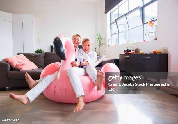 caucasian lesbian couple sitting on inflatable flamingo - funny lesbian 個照片及圖片檔