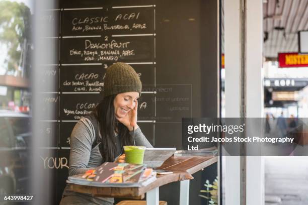 caucasian woman reading book in cafe - melbourne cafe stock-fotos und bilder