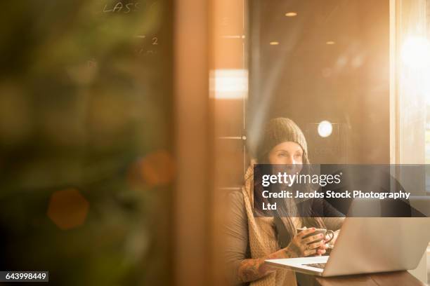 caucasian woman using laptop in cafe - white night melbourne stock pictures, royalty-free photos & images