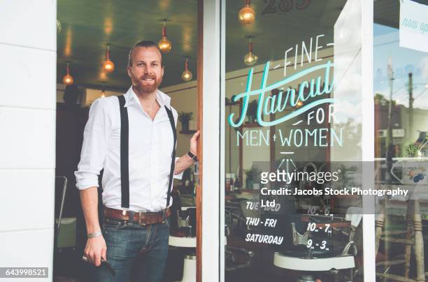 caucasian stylist standing in barber shop doorway - suspenders 個照片及圖片檔