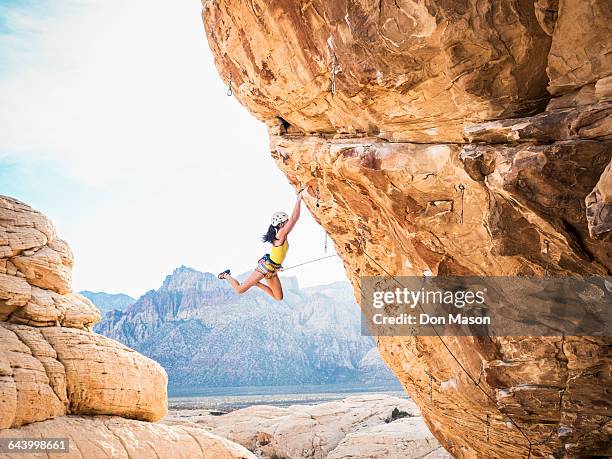mixed race girl rock climbing on cliff - sport climbing stock pictures, royalty-free photos & images