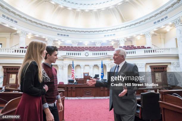 caucasian couple talking to politician in capitol building - museum tour stock pictures, royalty-free photos & images