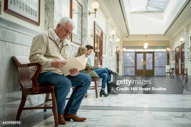 caucasian man waiting in courthouse hallway - inside courthouse stock pictures, royalty-free photos & images