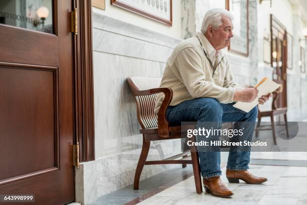 caucasian man waiting in courthouse hallway - inside courthouse stock pictures, royalty-free photos & images