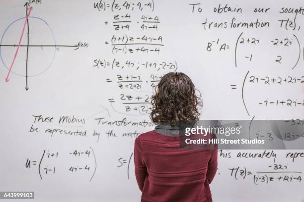 caucasian professor examining equations on whiteboard - mathematician stock pictures, royalty-free photos & images