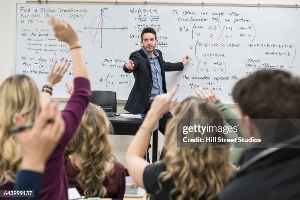 professor taking questions in college classroom - edificio público fotografías e imágenes de stock