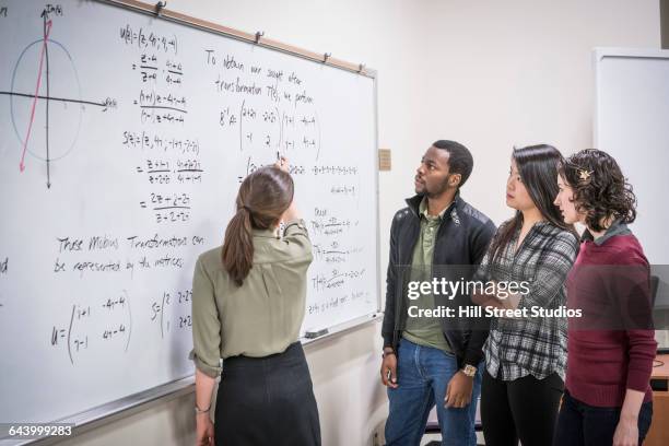 professor talking to students in college classroom - mathematician stock pictures, royalty-free photos & images