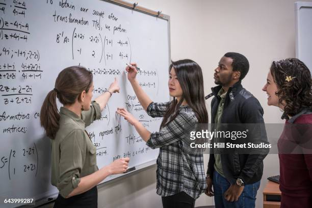 professor talking to students in college classroom - mathematician stockfoto's en -beelden