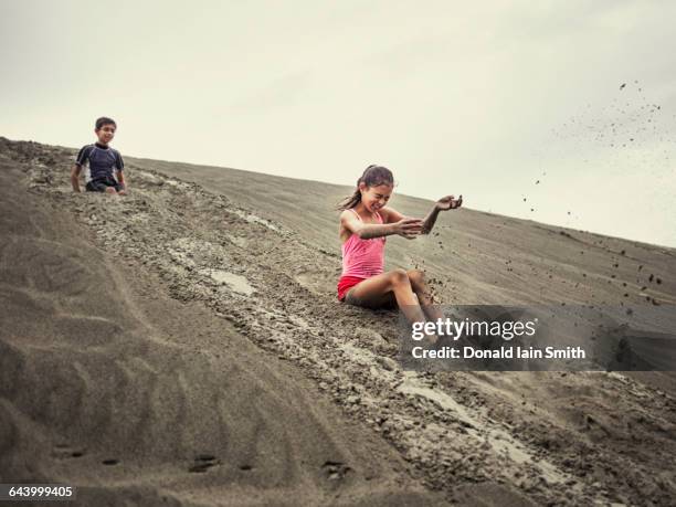 children sliding on sand dune - manawatu stock pictures, royalty-free photos & images