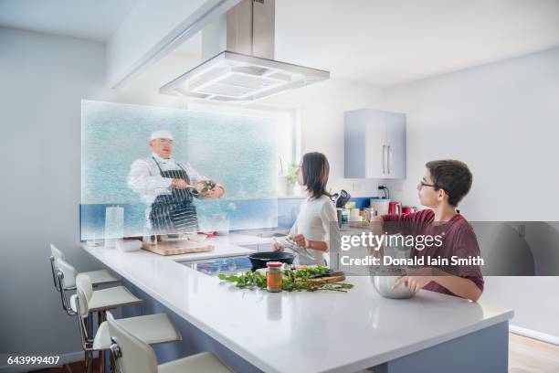 brother and sister watching hologram cooking show in kitchen - boy cooking stock pictures, royalty-free photos & images