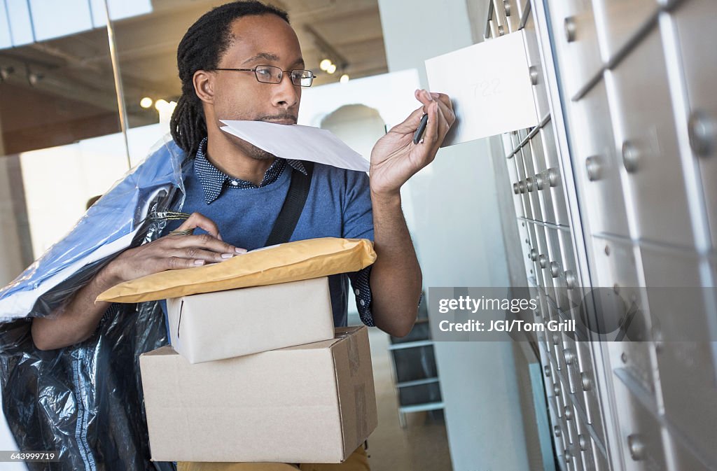 Black man gathering mail from post office box