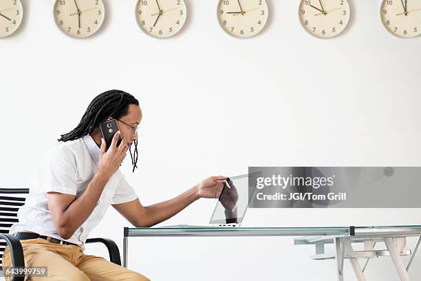 black businessman working in office - clock person desk stock pictures, royalty-free photos & images