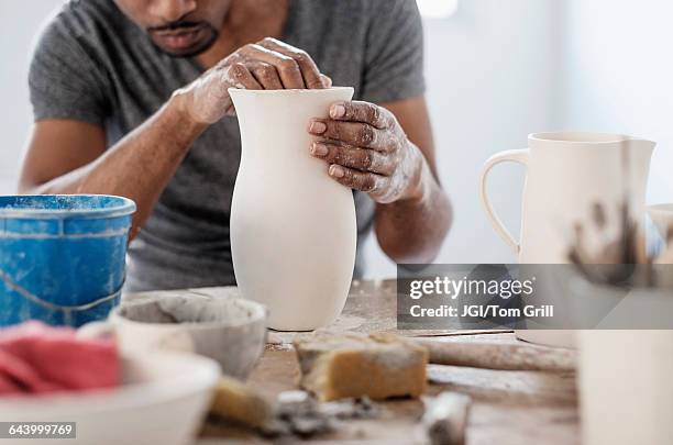 black artist shaping ceramic vase in studio - man pottery stock pictures, royalty-free photos & images