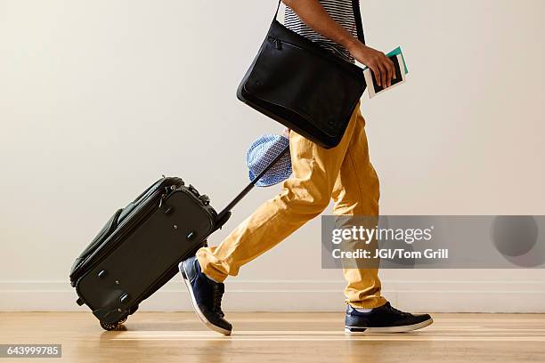 black businessman rolling luggage - carry on luggage photos et images de collection