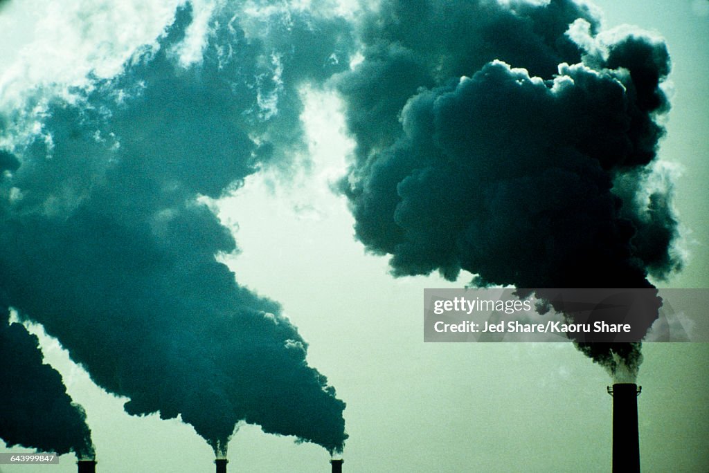 Smoke billowing from industrial smoke stacks