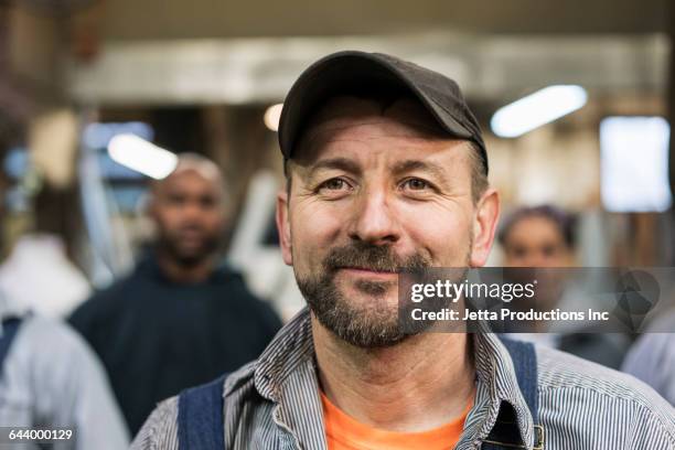 worker smiling in factory - blue collar portrait stock-fotos und bilder