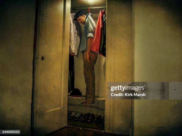 caucasian man hanging with clothing in closet - hanging death photos stock pictures, royalty-free photos & images