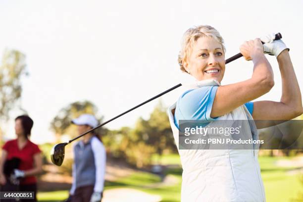 woman playing golf on golf course - golf short iron stock pictures, royalty-free photos & images