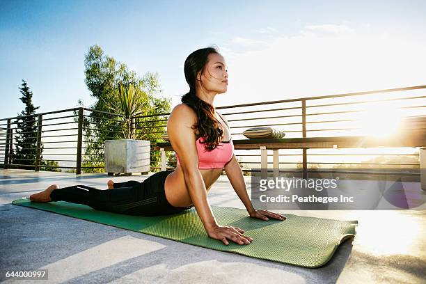chinese woman practicing yoga on balcony - asia ray stock-fotos und bilder