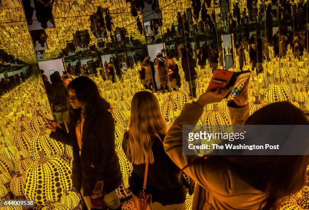 Volunteers experience the installation "Infinity Mirrored Room-All the Eternal Love I Have for the Pumpkins" as the Hirshhorn museum trains staff and...