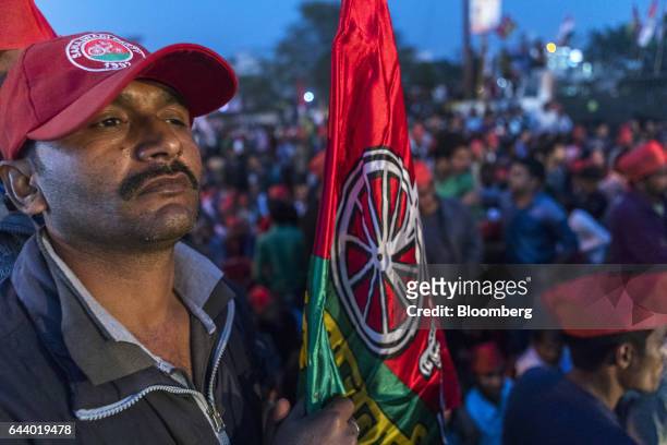 Supporter of the Samajwadi Party wears a cap and carries a flag featuring the party's emblem during a state election rally in Lucknow, Uttar Pradesh,...