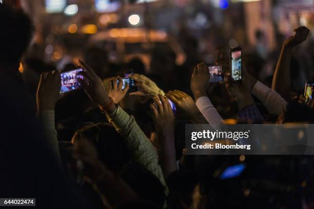 Supporters of the Samajwadi Party and Indian National Congress party take photographs on their smart phones during a state election rally in Lucknow,...