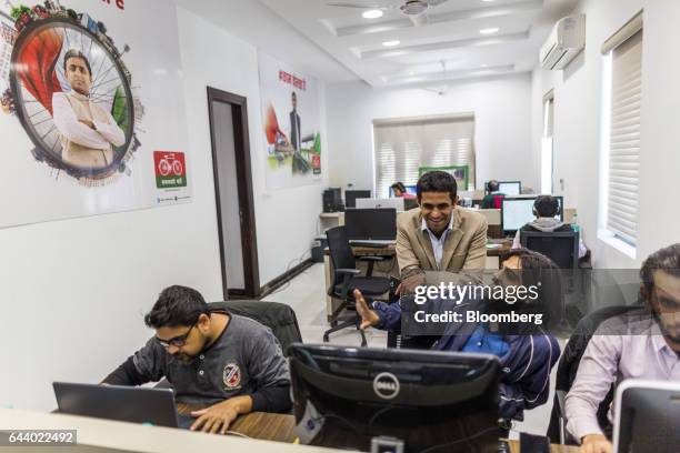 Volunteers of the Samajwadi Party work near a poster featuring an image of Akhilesh Yadav, chief minister of the state of Uttar Pradesh and president...