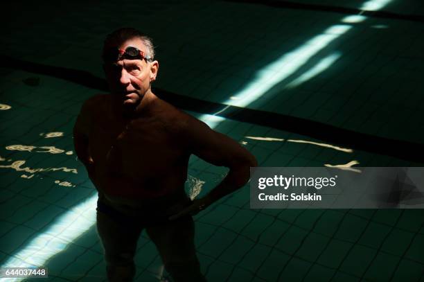 senior male swimmer standing in swimming pool - chiaroscuro - fotografias e filmes do acervo