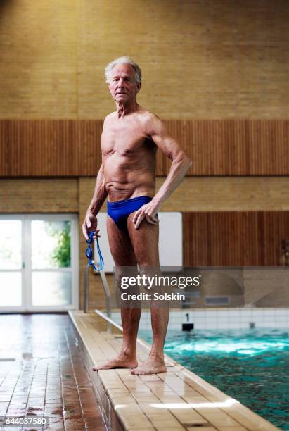 senior male swimmer standing on swimming pool edge - public pool stock pictures, royalty-free photos & images