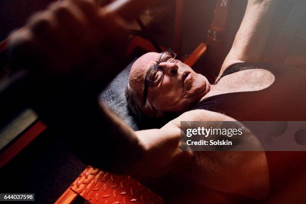 senior man lifting weights in gym - gym determination stock pictures, royalty-free photos & images