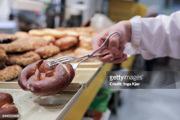 Berlin, Germany A baker takes a lye pretzel with a forceps from the display on February 06, 2017 in Berlin, Germany.