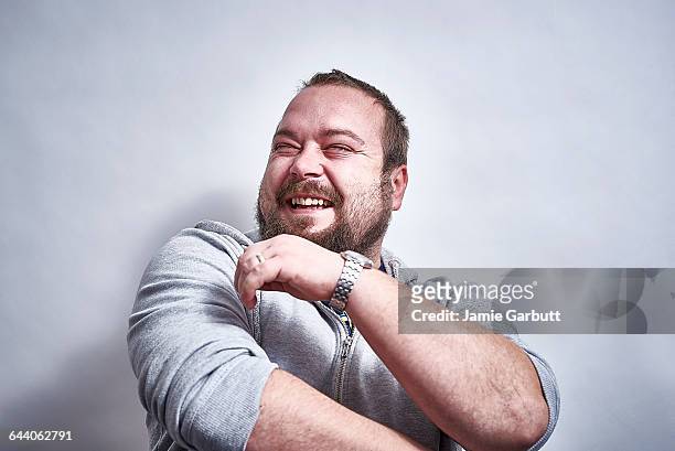 bearded british male laughing hysterically - lachen stock-fotos und bilder