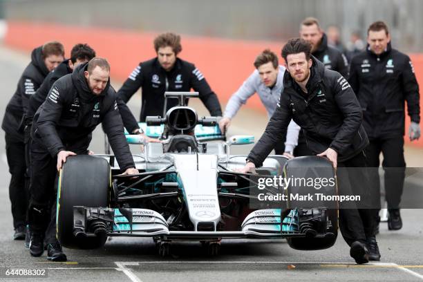 Members of the Mercedes GP wheel the car out for the launch of the Mercedes formula one team's 2017 car, the W08, at Silverstone Circuit on February...