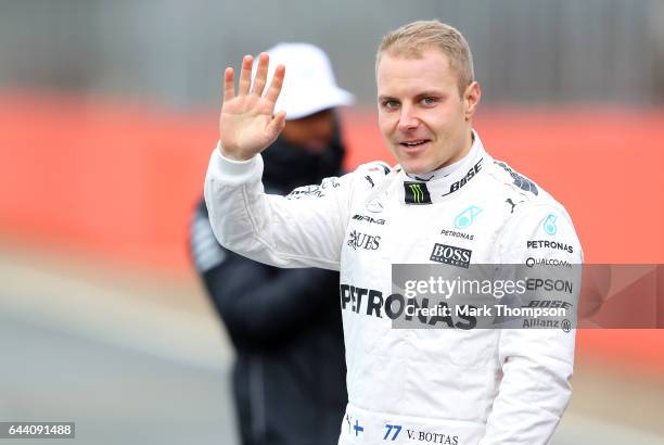 Valtteri Bottas of Finland and Mercedes GP waves as he poses with the car during the launch of the Mercedes formula one team's 2017 car, the W08, at...