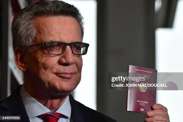 German Interior Minister Thomas de Maiziere presents the new German electronic passport on February 23, 2017 in Berlin during an official...