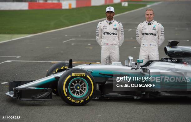 Mercedes AMG Petronas Formula One drivers Britain's Lewis Hamilton and Finland's Valtteri Bottas pose by the new 2017 season Mercedes W08 EQ Power+...