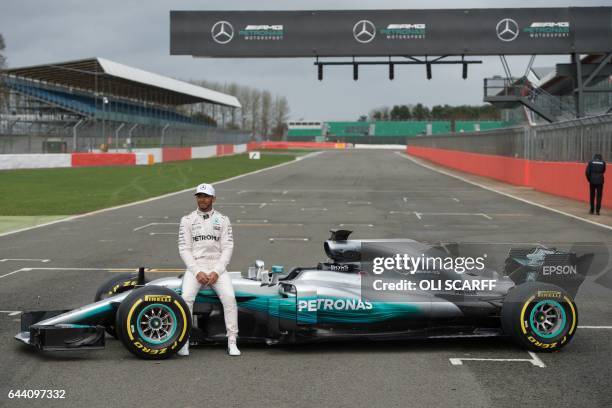 Mercedes AMG Petronas Formula One driver Britain's Lewis Hamilton poses by the new 2017 season Mercedes W08 EQ Power+ Formula One car at its launch...