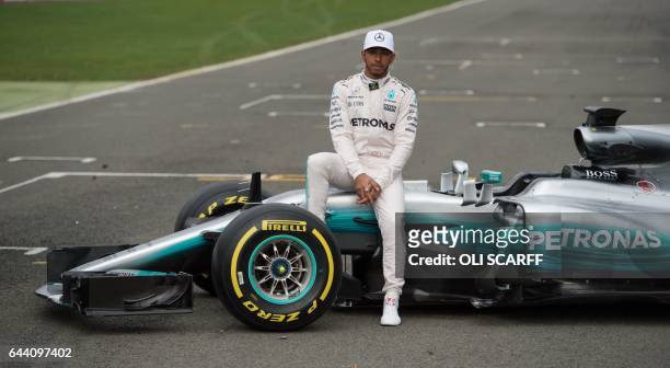 Mercedes AMG Petronas Formula One driver Britain's Lewis Hamilton poses by the new 2017 season Mercedes W08 EQ Power+ Formula One car at its launch...