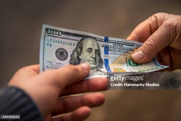 unrecognizable person giving other person usa dollar bill - 100 bills stock pictures, royalty-free photos & images