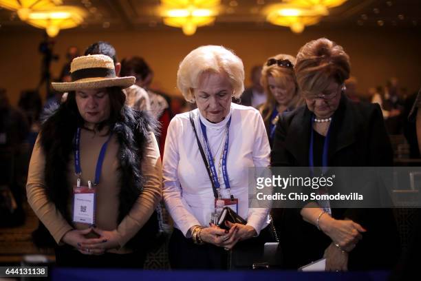 Attendants bow their heads in prayer during the first day of the Conservative Political Action Conference at the Gaylord National Resort and...