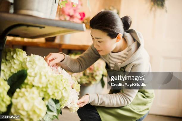 lavoratrice matura che lavora in un negozio di fiori. - mature asian woman candid foto e immagini stock