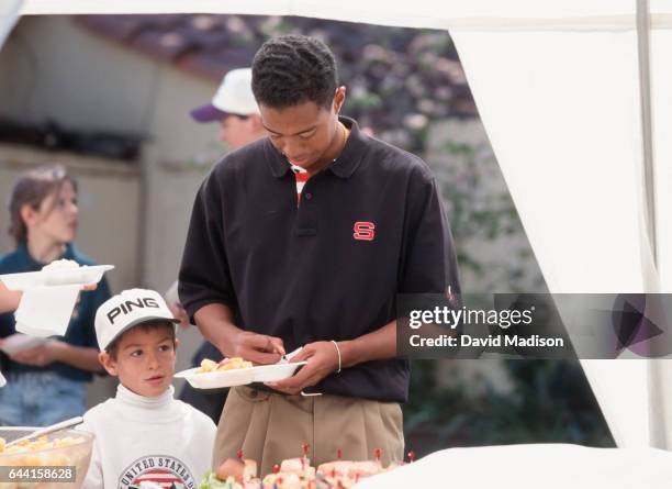 Tiger Woods of Stanford University signs an autograph for a young fan during an NCAA golf tournament in 1995 on the Stanford University Golf Course...