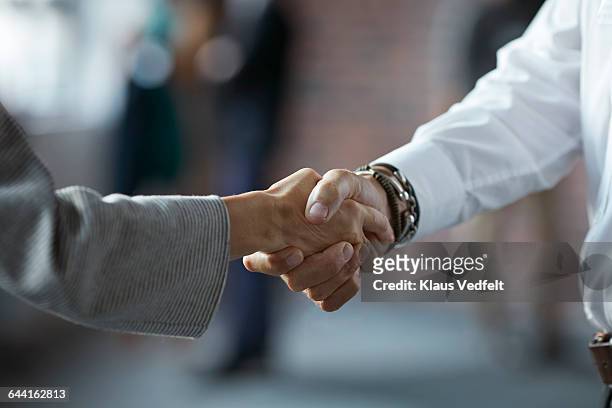 businesspeople making handshake at conference - partnership teamwork stock-fotos und bilder