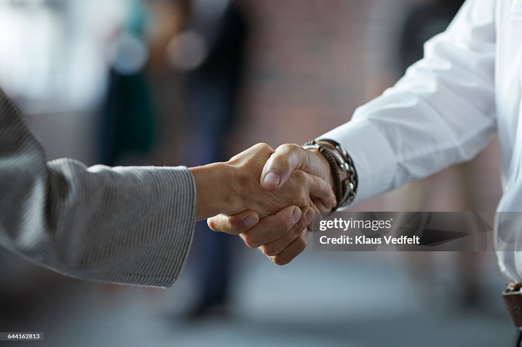 Businesspeople making handshake at conference