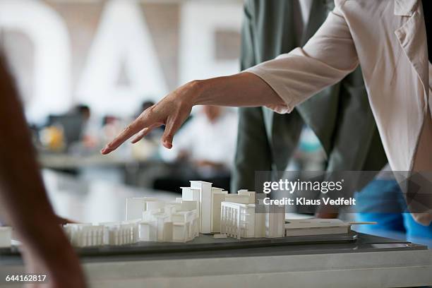 co-workers gathered around architectural model - architectural model stockfoto's en -beelden