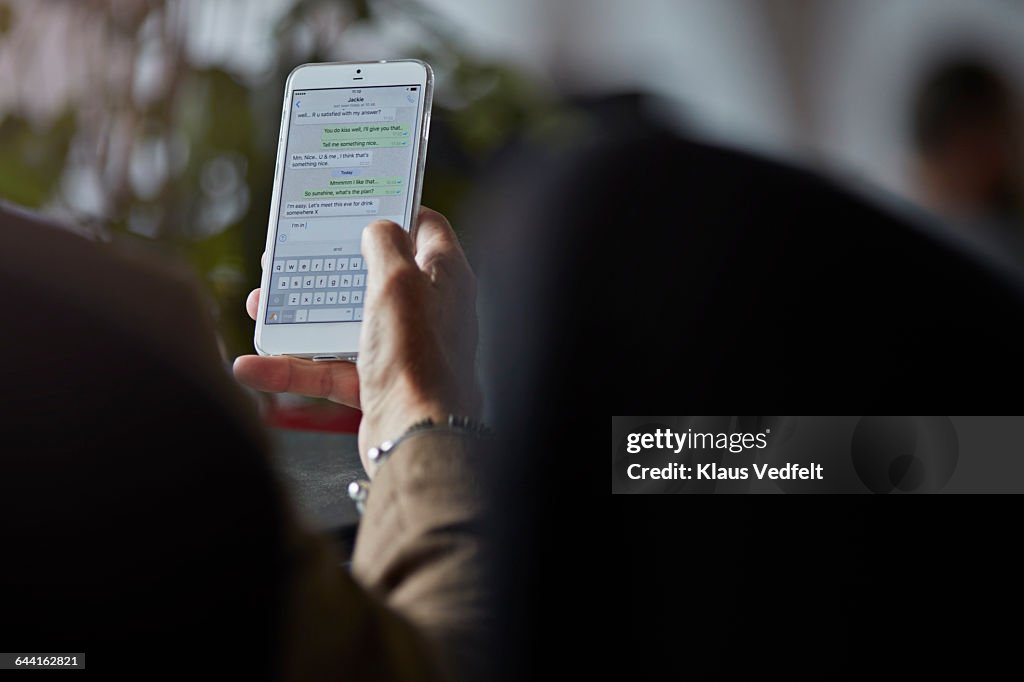 Close-up of man texting with girl friend on phone