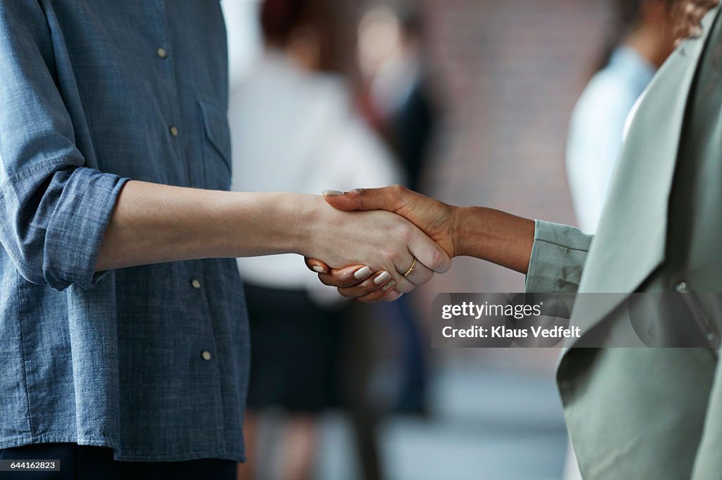 Businesswomen making handshake at conference