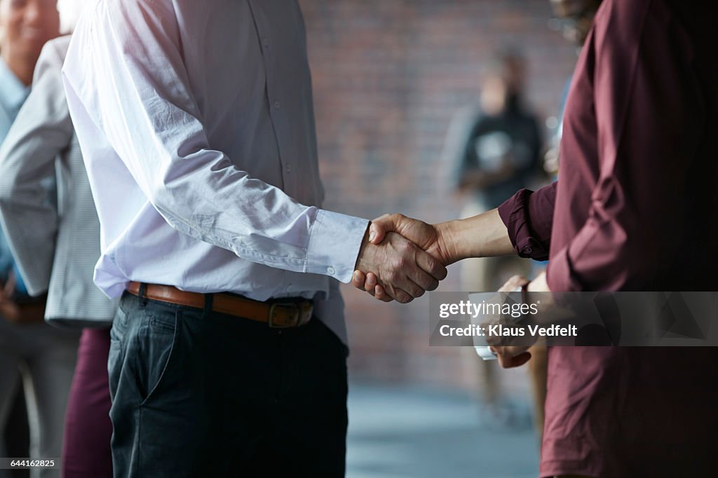 Businessmen making handshake at conference