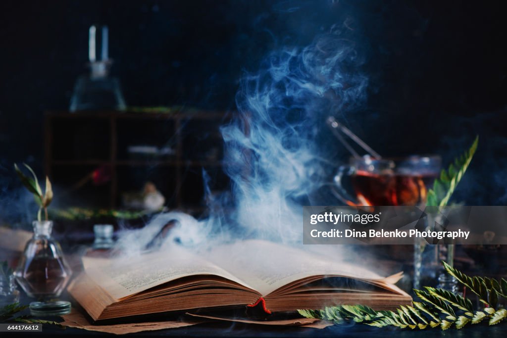 Open spell book with magical smoke